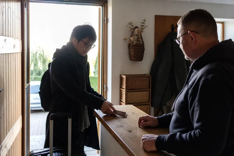 Gast legt bei der Ankunft in einer Ferienwohnung einen Reisepass auf einen Tisch